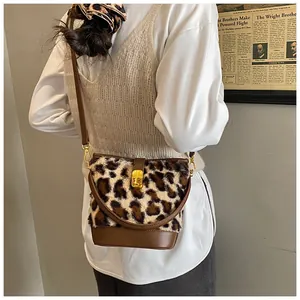 Detail van pluche bucket bag met luipaardprint, leren basis en gouden metalen slot
