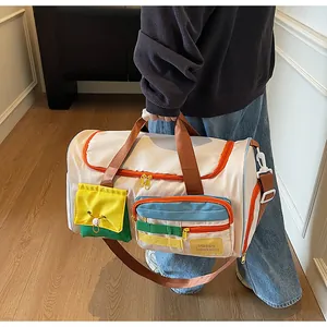 Detail of multi-color travel bag with front pockets and Happy Weekend text logo
