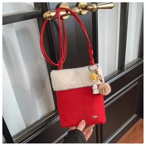 Détail du sac bandoulière en daim rouge avec bordure en peluche blanche et breloques étoile