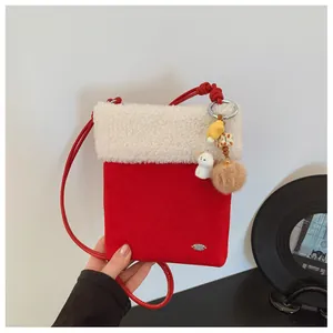 Détail du mini sac bandoulière hiver en daim rouge avec bordure en peluche et charme chien