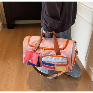 Detailed view of the multi-pocket pink travel bag with colorful zippers and gold hardware