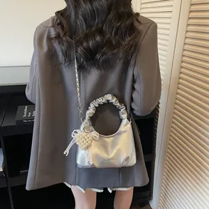 Silver metallic pleated handbag with pearl heart charm and lace bow in a fashion street style