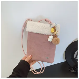 Détail du sac bandoulière en daim rose avec bordure en peluche et breloque chien mignon
