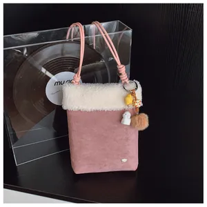 Détail du sac à bandoulière rose en peluche avec bordure en fourrure et pendentif