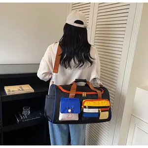 Detail of multi-color travel bag with orange straps worn by model in a cozy indoor setting