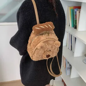 Cute brown plush bear backpack with baguette detail and adjustable straps on model