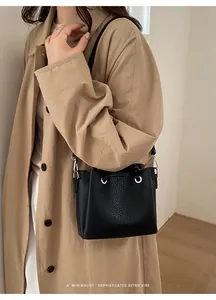 Detail of black lychee leather bucket bag with silver metal eyelets and drawstring closure