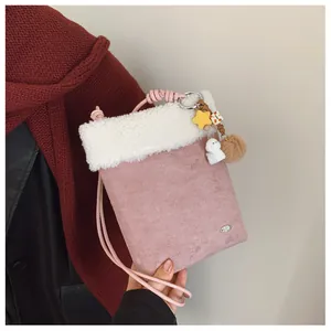 Détail du sac en daim rose avec bordure en peluche et breloques décoratives mignonnes