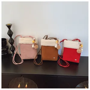 Trois sacs à bandoulière en peluche rose, marron et rouge avec charms décoratifs