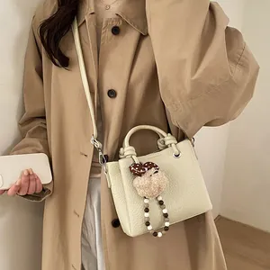 Chic cream white leather crossbody bucket bag with cute plush pendant and pearl charms