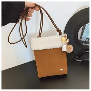 Détail de la bandoulière en suédine avec bordure en peluche et jolis charmes