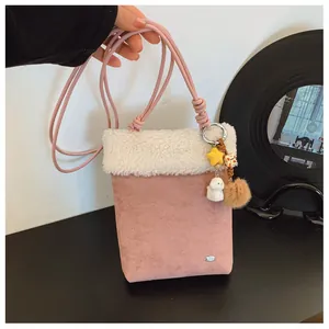 Détail du sac bandoulière rose en suédine avec bordure en peluche et pendentif chiot
