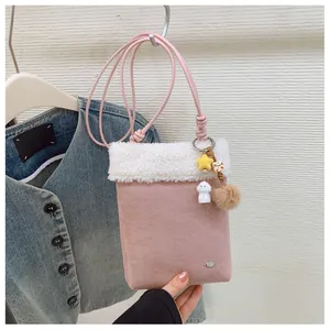 Gros plan détaillé du sac à bandoulière rose en daim avec bordure en peluche douce