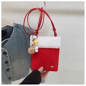 Détail du sac bandoulière rouge en peluche avec bordure en fourrure et breloques chien
