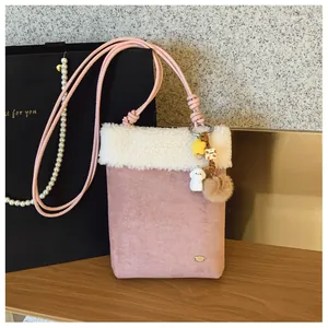 Détail du sac bandoulière en peluche rose avec bordure en fourrure et charmant pendentif