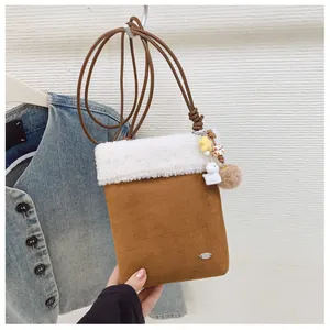 Détail du sac en daim marron avec bordure en peluche et breloques en forme d'étoile