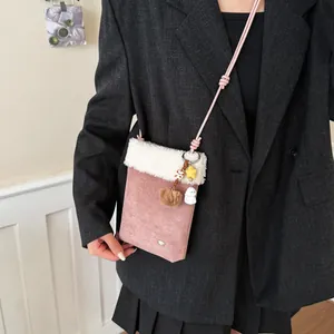 Sac à bandoulière en daim rose avec bordure en peluche blanche et pendentifs