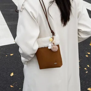 Sac bandoulière chic en daim marron avec bordure en polaire blanche et breloques peluche