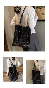 Detailed embroidery on a black velvet tote bag with vintage floral patterns and quilted texture