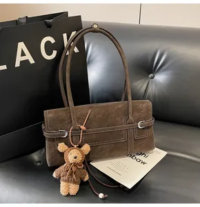 Detail of dark brown retro baguette bag with white stitching and plush bear charm