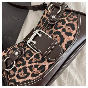 Close-up of leopard print fabric with leather strap and silver metal buckle detail