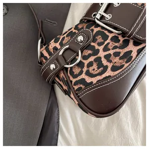 Close-up of leopard print shoulder bag with silver buckle and white contrast stitching