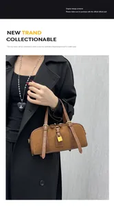 Detail of brown Boston bag featuring suede and leather texture with a gold padlock