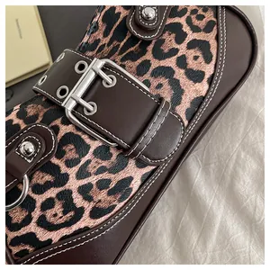 Detail of leopard print handbag with large silver buckle and white stitching accents