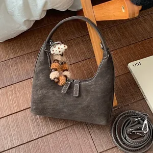 Retro graubraune Halbmond-Handtasche aus Wildleder mit Kontrastnähten und weichem Anhänger