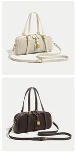 Close-up of retro Boston bags in beige and coffee with gold locks and shoulder straps