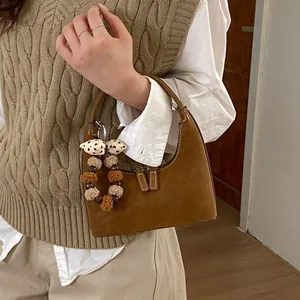 Braune Wildleder-Halbmondtasche mit Ziernähten und niedlichem Bommel-Anhänger