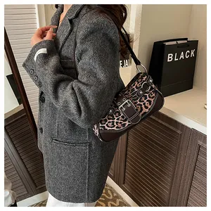 Detail of leopard print baguette bag with brown leather strap and silver buckle accent
