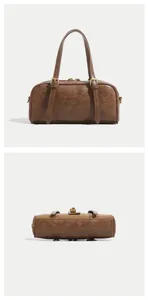 Detail view of brown Boston bag showing vintage PU leather texture and buckle straps