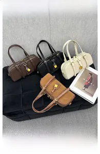 Top view of Boston bags in four colors arranged on a luxury black bench with gold locks