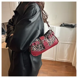 Close-up of leopard print underarm bag with red trim and silver buckle detailing