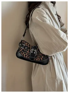 Detail of leopard print shoulder bag featuring vintage silver buckle and rivet accents