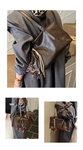 Close-up of vintage brown leather tote bag with dog charm and adjustable shoulder strap