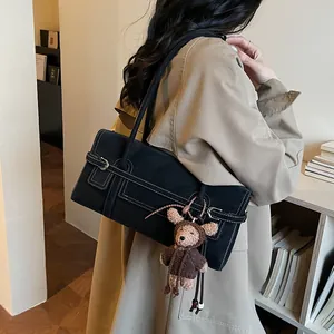 Retro black faux suede shoulder bag with contrast stitching and a cute bear charm