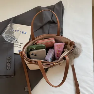 Dettagli interni di una borsa tote patchwork con cerniera e ciondolo di peluche
