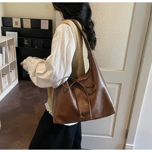 Close-up of vintage brown leather tote bag with bow detail and large capacity interior