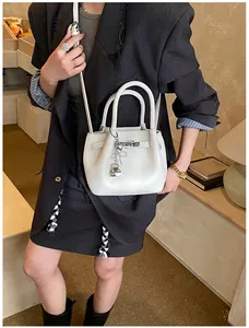 Detailansicht der weißen Bucket Bag mit Litschistruktur, Silberbeschlägen und Vorhängeschloss