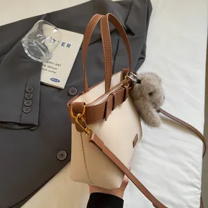 Dettaglio della pelle sintetica e tracolla regolabile per borsa a mano beige e marrone