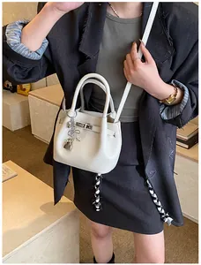 Detailaufnahme der weißen Lederstruktur mit Lychee-Muster und elegantem Vorhängeschloss