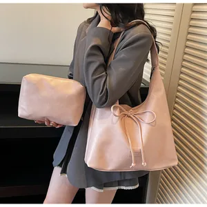 Close-up of pink bow tote bag and matching pouch showing matte faux leather texture