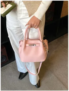 Rosafarbene Eimertasche mit Lychee-Maserung, silbernem Drehverschluss und Schultergurt