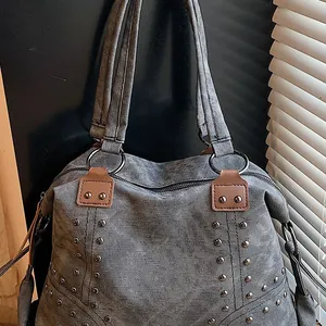 Vintage gray canvas tote bag with metal rivets and brown leather strap detail