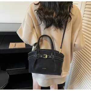 Detail of minimalist black matte handbag with ZHCNMA logo and detachable shoulder strap