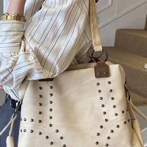 Vintage beige tote bag with metallic rivet accents and textured lychee pattern finish