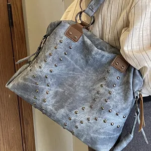 Vintage rivet tote bag in washed blue-grey canvas shown on model for daily style