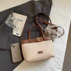 Dettaglio borsa patchwork in pelle scamosciata con fibbia e ciondolo a coniglio